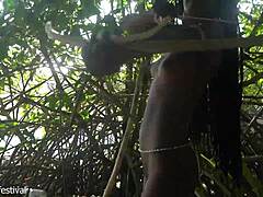skinny tribe woman crafts bow for hunting outdoors