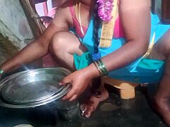 Indian sexy aunty carefully cleans plates in her outdoor home setting with friends