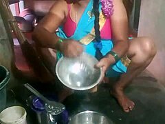 Indian sexy aunty carefully cleans plates in her outdoor home setting with friends