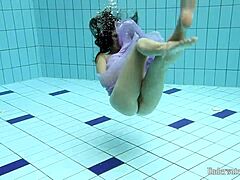 Blackhaired Aneta dives gracefully into the refreshing pool waters