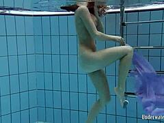Blackhaired Aneta dives gracefully into the refreshing pool waters