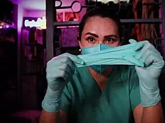 Masked nurse in latex gloves performs fetish roleplay on patient in hospital
