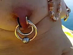 Nippleringlover, kinky mom with extreme pierced nipples and pussy, goes nude on beach! 🏖️