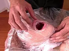 Leyla Black is bound in plastic and tape for a submissive session.