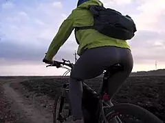 fit girl rides bicycle in tight yoga pants from behind