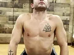 muscular bodybuilder performs intense stretching routine