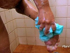 Latina beauty with short hair and natural tits teases her big pussy and nipples in the shower using a vibrator.