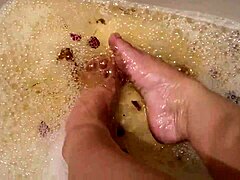 Sexy tattooed babe washes bare feet with rose petals softly