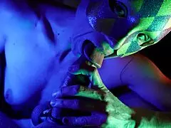 Masked adult bites penis head and foreskin during blowjob, leading to cum in mouth.