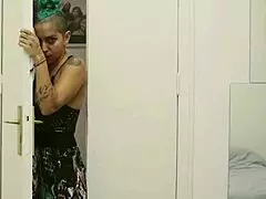 Short tattooed girl with green hair teases in hot striptease, ripping clothes