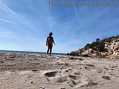 Kurvige fremde Nudistin spielt mit Dildo am Strand