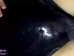 Transsexual in navy blue swimsuit gets coated with slippery lotion