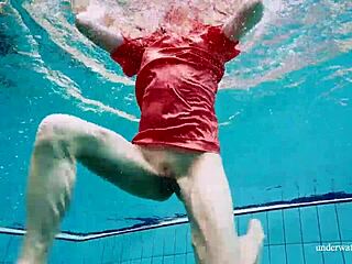 Cute russian babe swims underwater in red open dress