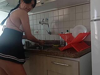 She casually washes the dishes in the kitchen.