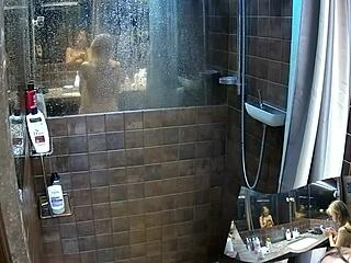 voyeur watches two girlfriends showering naked in bathroom together.