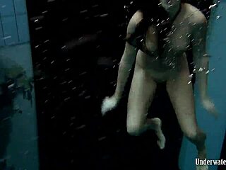 Blackhaired Aneta dives gracefully into the refreshing pool waters