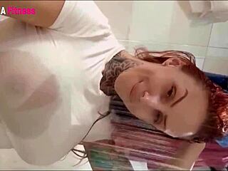 redhead teases with big tits pushing through her wet white blouse up close