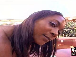 Oiled ebony bends over outside shaking ass on big black cock