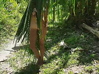 a tall naked beauty poses exposed amid the wild amazon jungle foliage