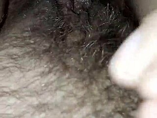 Milf squeezes her hairy pussy lips sensually in fetish closeup