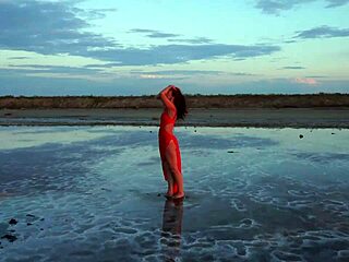 Woman walks along elton salt lake during stunning red sunset