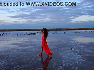 Woman walks along elton salt lake during stunning red sunset