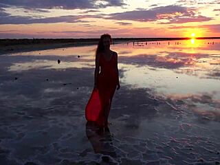 Woman walks along elton salt lake during stunning red sunset