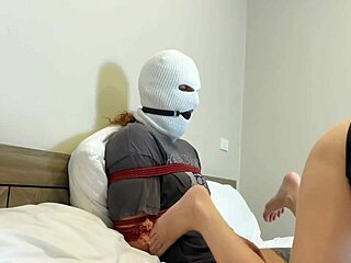 Masked slave dude bound for girlfriend's fetish footjob torment.
