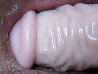 intimate view of deep toy insertion in slick folds with massive dildo