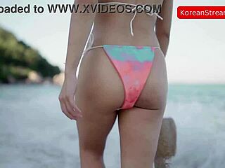 Sexy asian model walks along beach in bikini