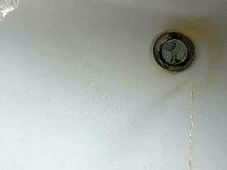 Boy is pissing in the sink and makes stinky farts